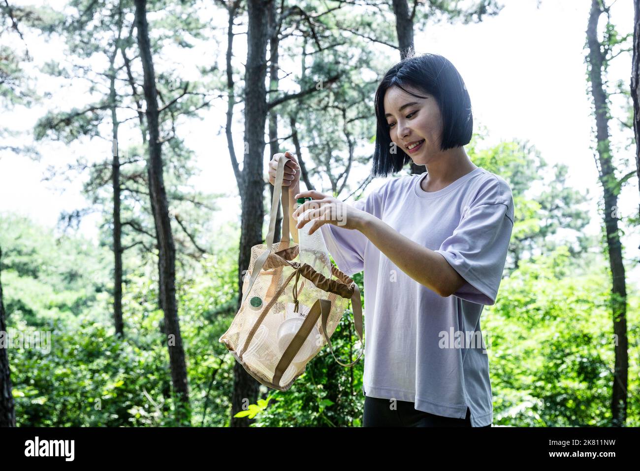 korean young woman hiking and plogging picking up litter, garbage Stock Photo Alamy