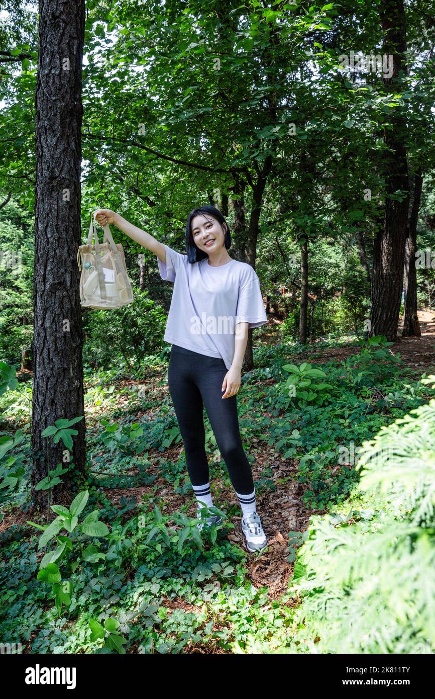 korean young woman hiking and plogging picking up litter, garbage Stock Photo Alamy