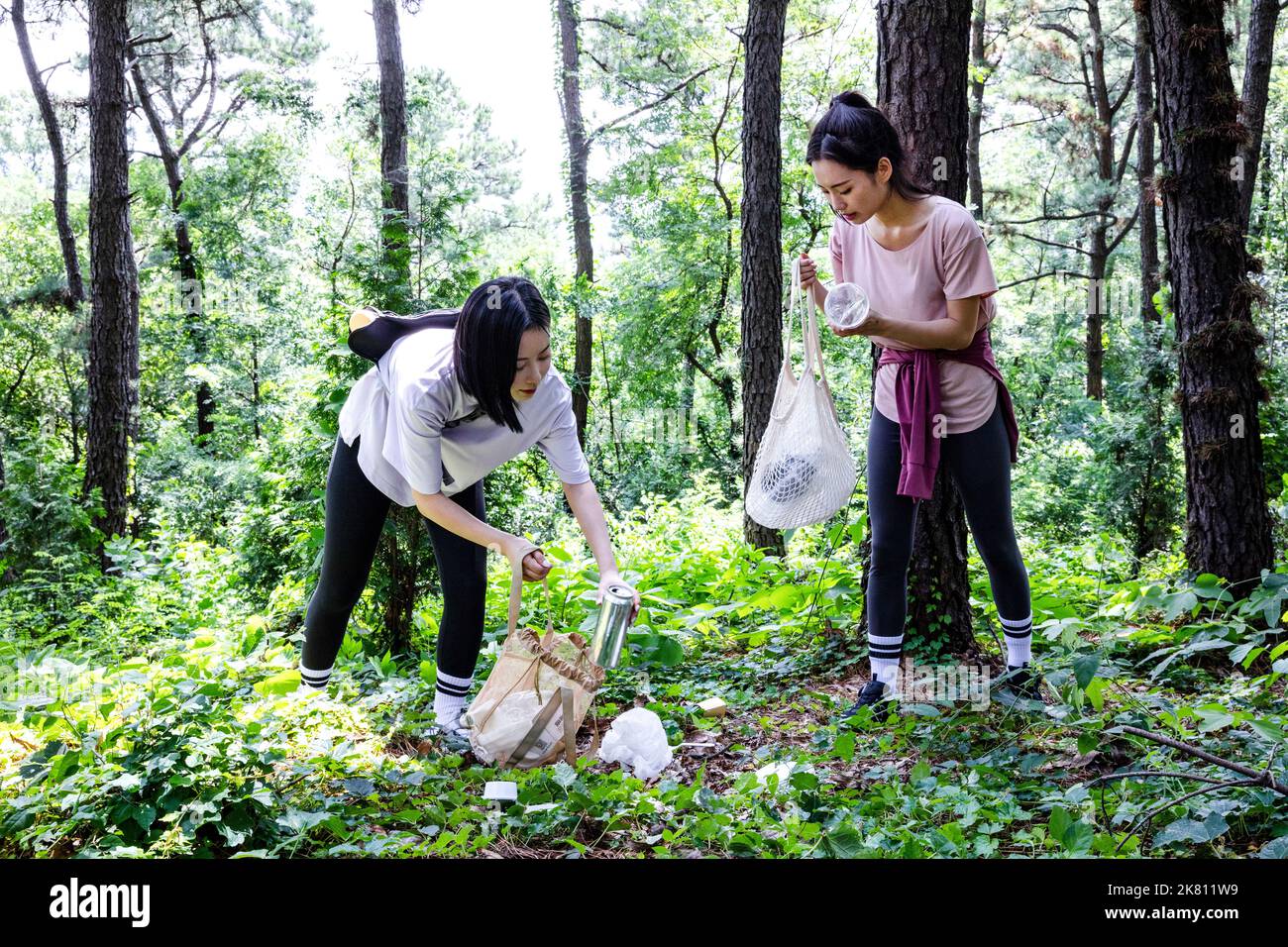 korean young women hiking and plogging picking up litter, garbage Stock Photo Alamy