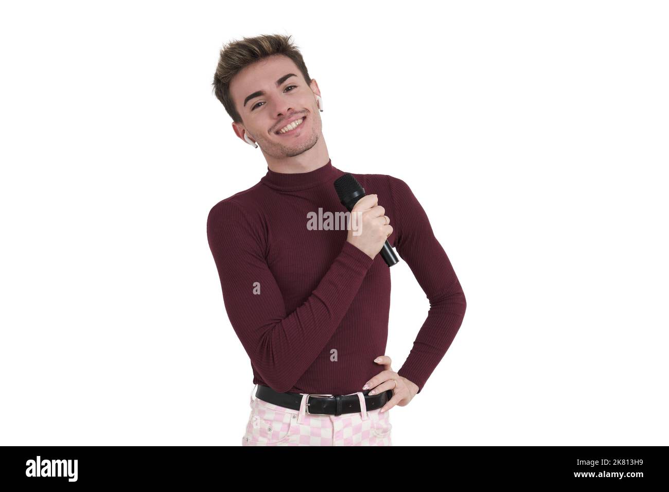 Young caucasian man smiling with a microphone, isolated. Stock Photo