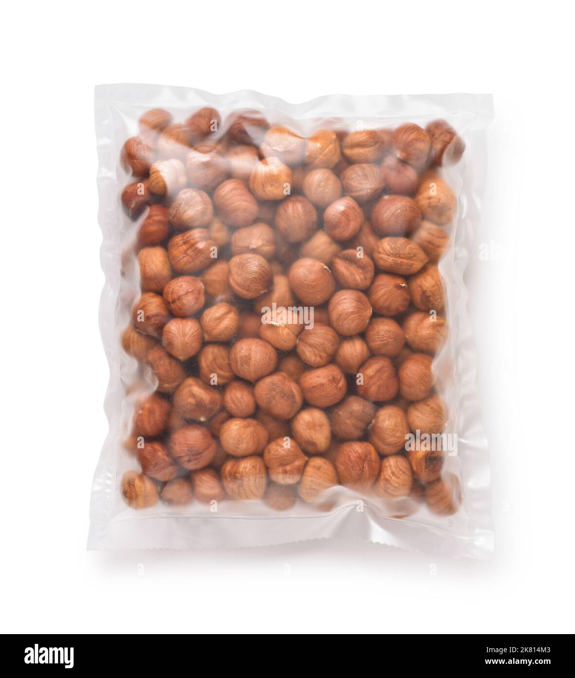 Top view of shelled hazelnuts in transparent plastic bag isolated on white Stock Photo