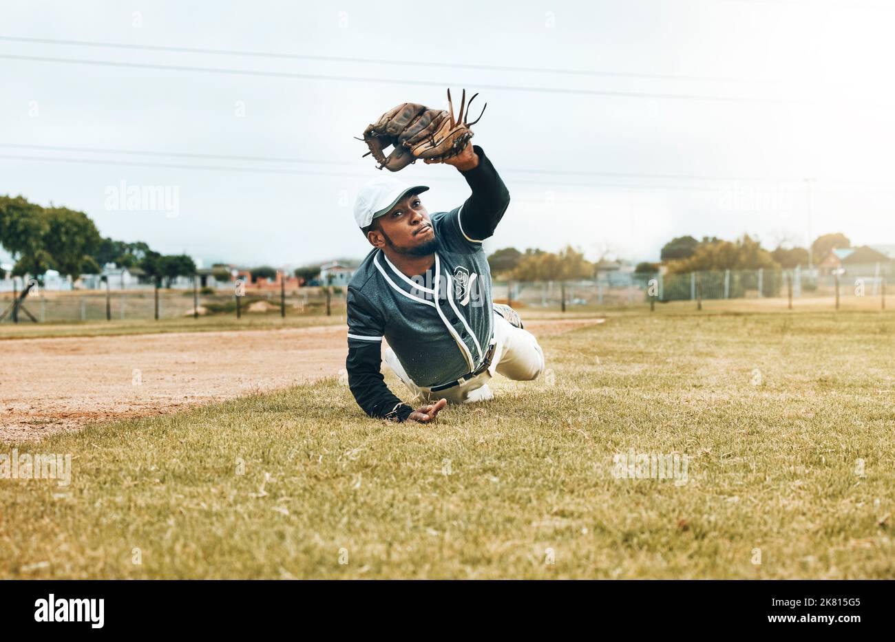 Baseball, sports and catch with a man athlete catching a ball during a game or match on a field for sport. Fitness, exercise and training with a Stock Photo