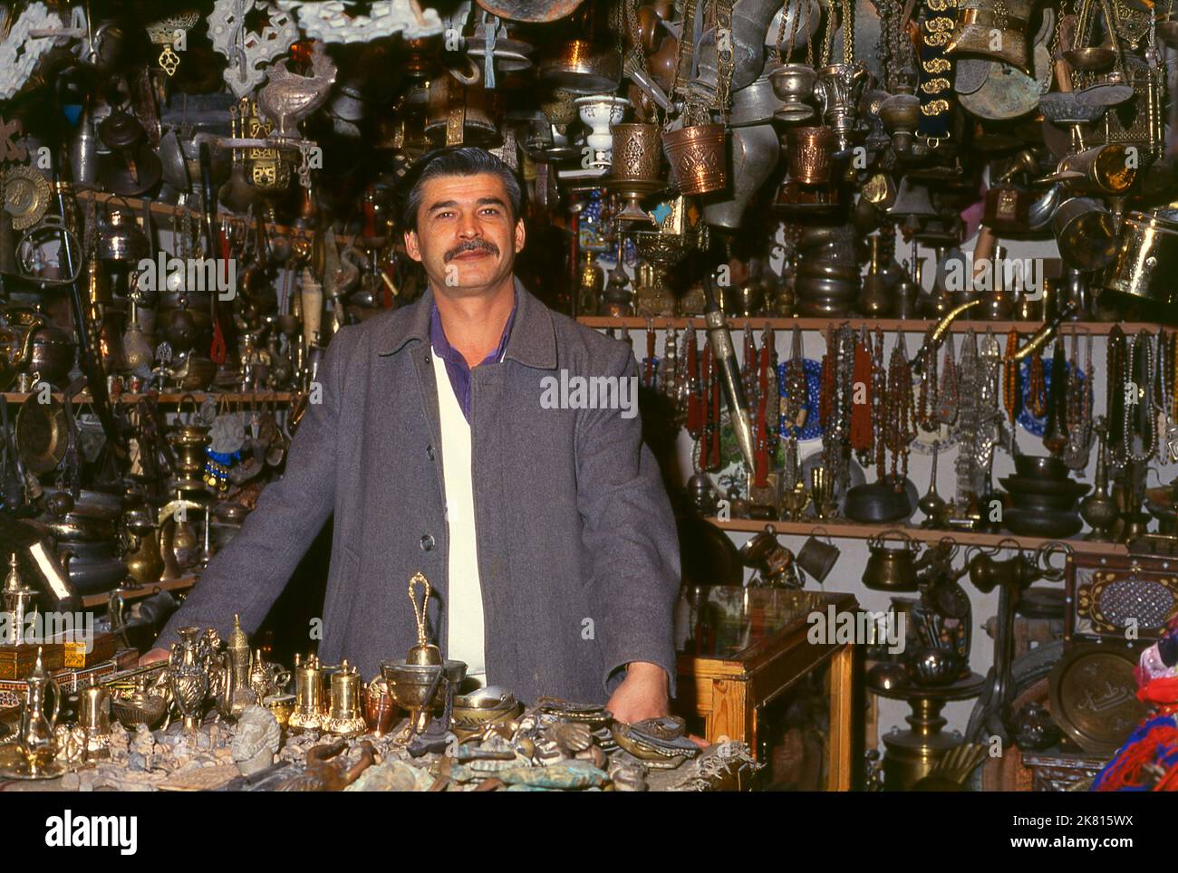Syria: A brass and metal goods vendor in the ancient Great Bazaar, Aleppo (1997). Aleppo's Great Bazaar (in Arabic, suq or souq) was rebuilt first by the Egyptian Mamelukes who drove out the Mongols, and then, after 1516, by the Turks who incorporated Aleppo into the Ottoman Empire. During the Syrian Civil War, which started in 2011, Aleppo's historic suqs suffered serious damage.  Aleppo, the second city of Syria is possibly the longest continually inhabited settlement in the world. Its Arabic name, Halab, is mentioned in Semitic texts of the third millennium BCE. Stock Photo