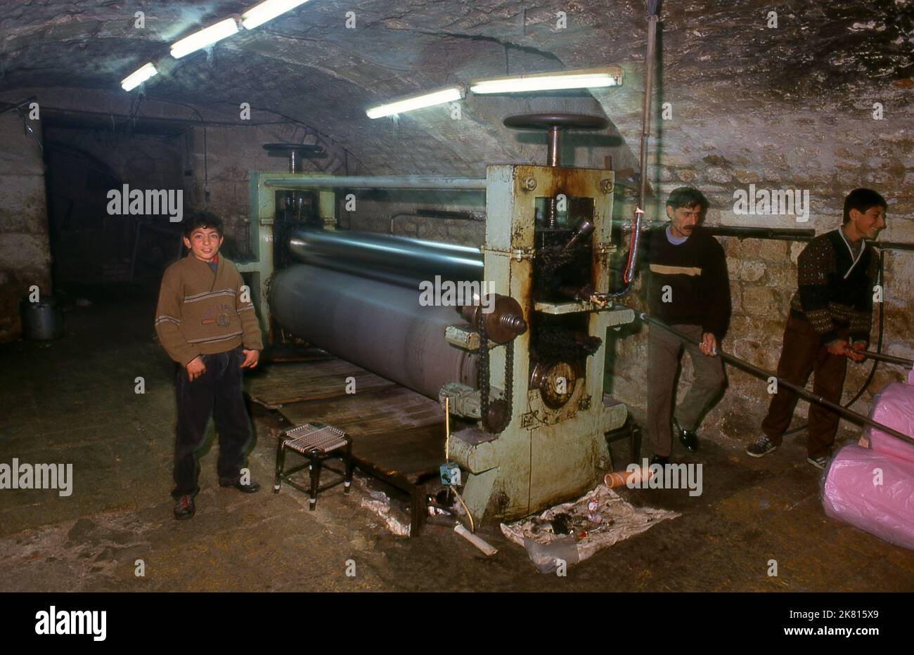 Syria: Subterranean cloth dyeing operation in the ancient Great Bazaar, Aleppo (1997). Aleppo's Great Bazaar (in Arabic, suq or souq) was rebuilt first by the Egyptian Mamelukes who drove out the Mongols, and then, after 1516, by the Turks who incorporated Aleppo into the Ottoman Empire. During the Syrian Civil War, which started in 2011, Aleppo's historic suqs suffered serious damage.  Aleppo, the second city of Syria is possibly the longest continually inhabited settlement in the world. Its Arabic name, Halab, is mentioned in Semitic texts of the third millennium BCE. Stock Photo