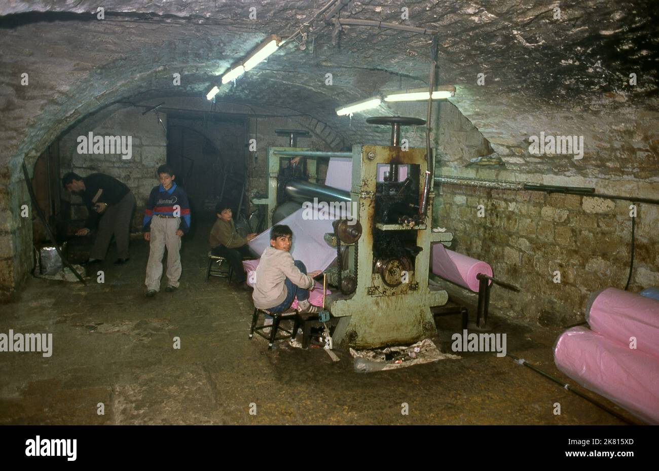 Syria: Subterranean cloth dyeing operation in the ancient Great Bazaar, Aleppo (1997). Aleppo's Great Bazaar (in Arabic, suq or souq) was rebuilt first by the Egyptian Mamelukes who drove out the Mongols, and then, after 1516, by the Turks who incorporated Aleppo into the Ottoman Empire. During the Syrian Civil War, which started in 2011, Aleppo's historic suqs suffered serious damage.  Aleppo, the second city of Syria is possibly the longest continually inhabited settlement in the world. Its Arabic name, Halab, is mentioned in Semitic texts of the third millennium BCE. Stock Photo
