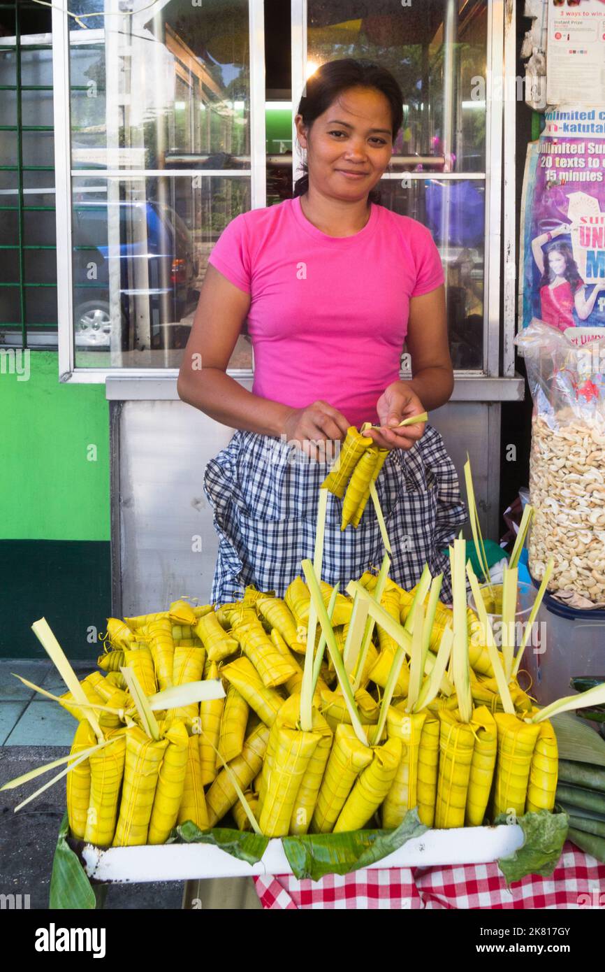 Traditional rice cakes wrapped in coconut leaves at a market in