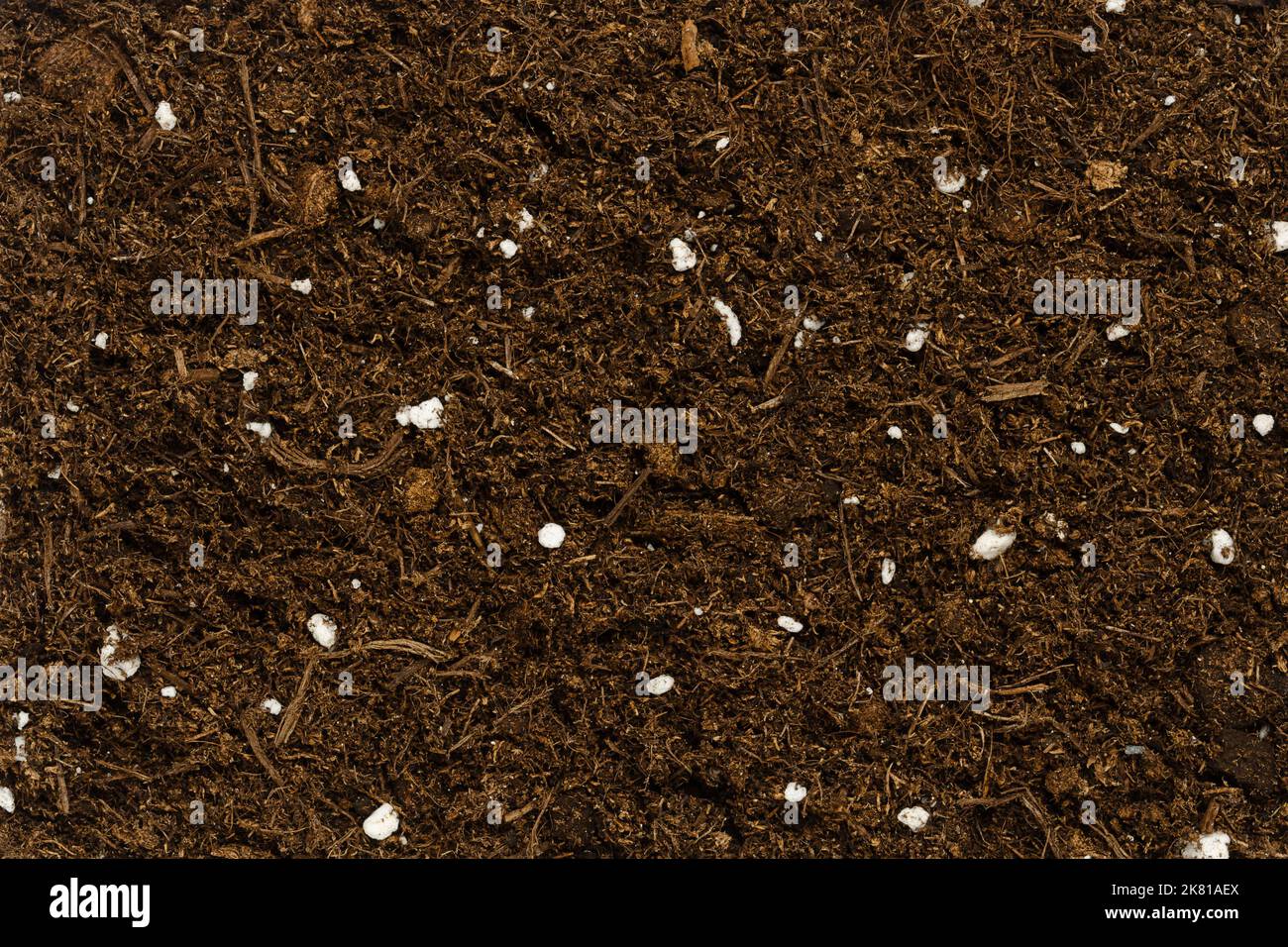Organic potting compost, background, from above. Soil, growing medium and culture substrate for sowing. Raised bog peat, humus, fibers and fertilizer. Stock Photo
