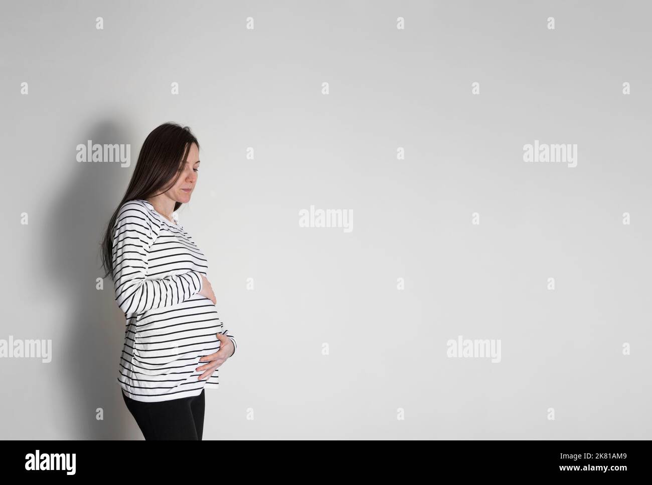 Worried pregnant woman with a sad look on her face, thinks about pregnancy laws. Stock Photo