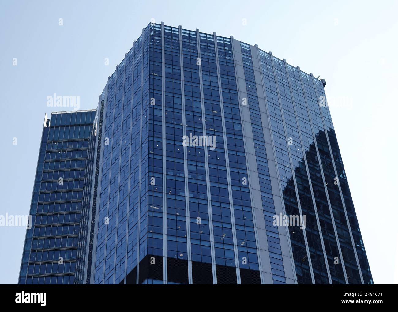 A low-angle shot of a modern blue glass office building in London, UK ...