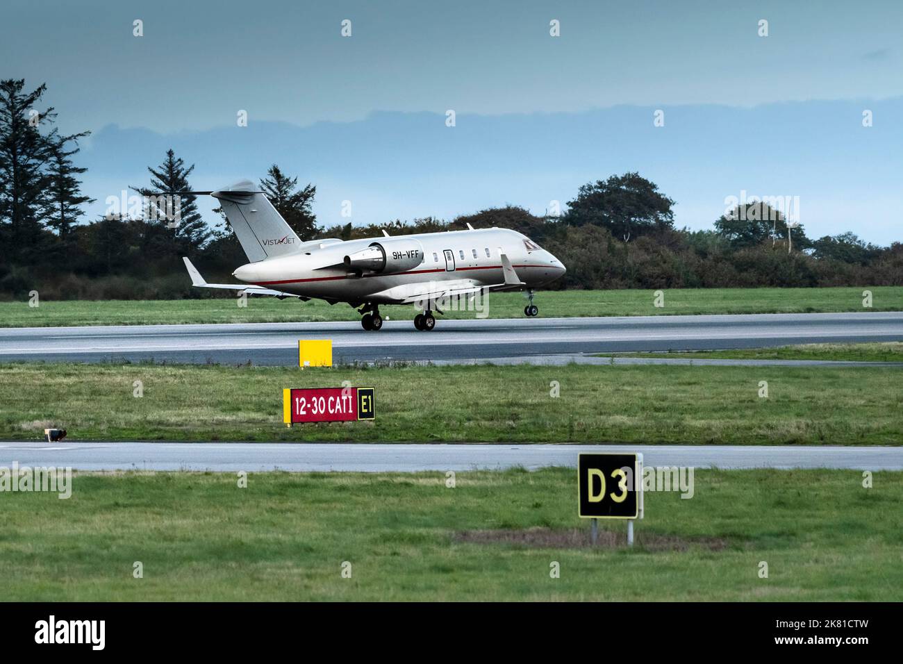 A Bombardier Challenger 605 9H-VFF Vista Jet taking off from the runway at Newquay Airport in Cornwall in the UK. Stock Photo