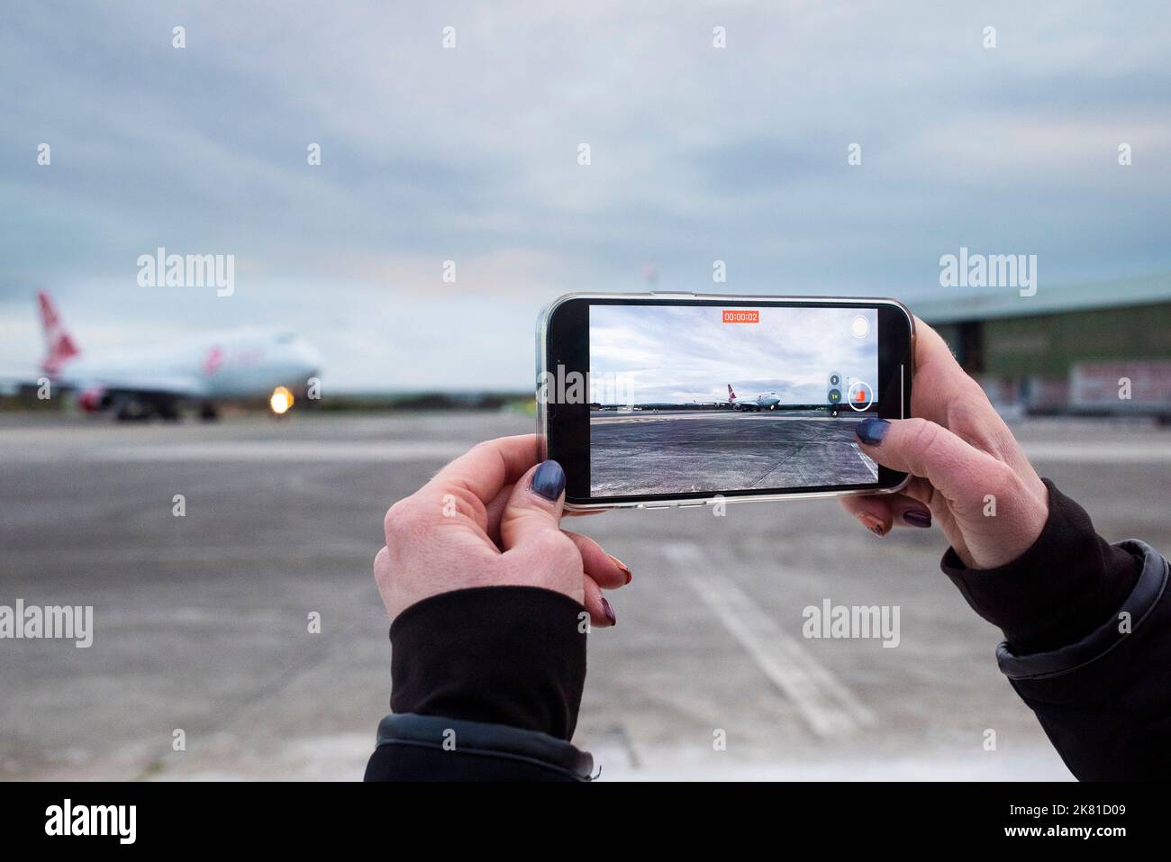 Seen on the screen of a spectators smartphone the Virgin Orbit, Cosmic Girl, a 747-400 converted to a rocket launch platform taxis to a halt on the ru Stock Photo