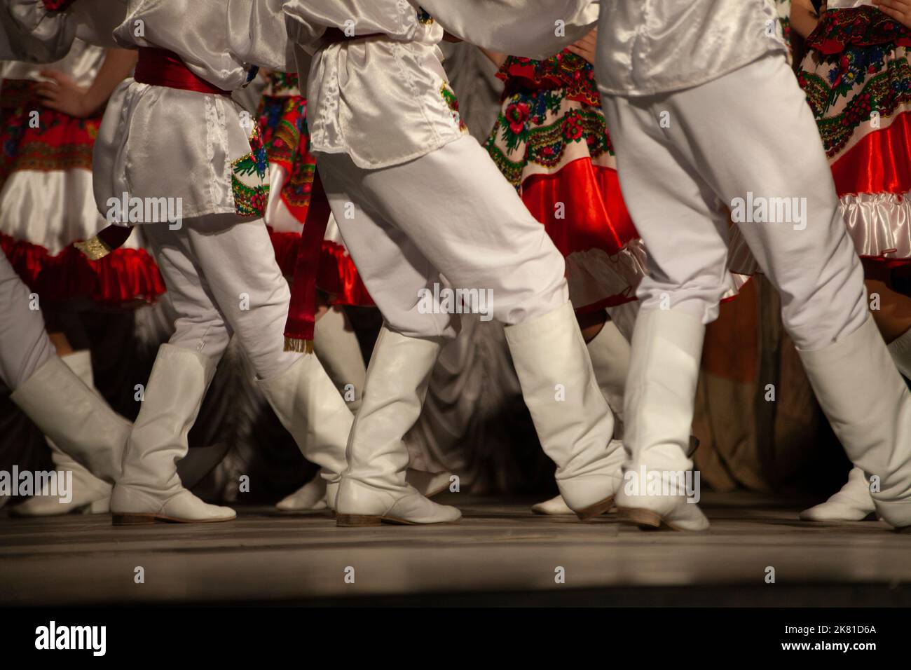 Folk dance. White boots. Dance lesson on stage. Foot movement details. Synchronized dance of