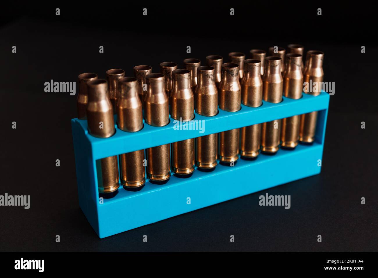 Amber gold empty bullet cases in blue holder Stock Photo - Alamy