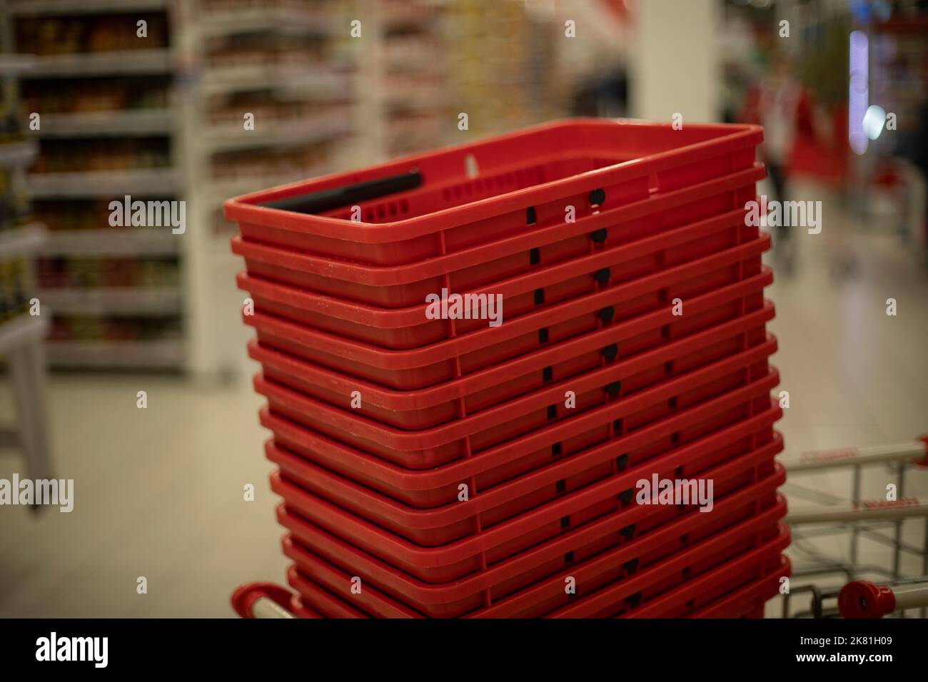 Red baskets for products. Grocery basket in store. Supermarket details