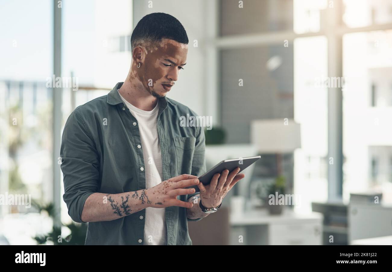 Know something nobody else knows. a young business man using a tablet at work. Stock Photo