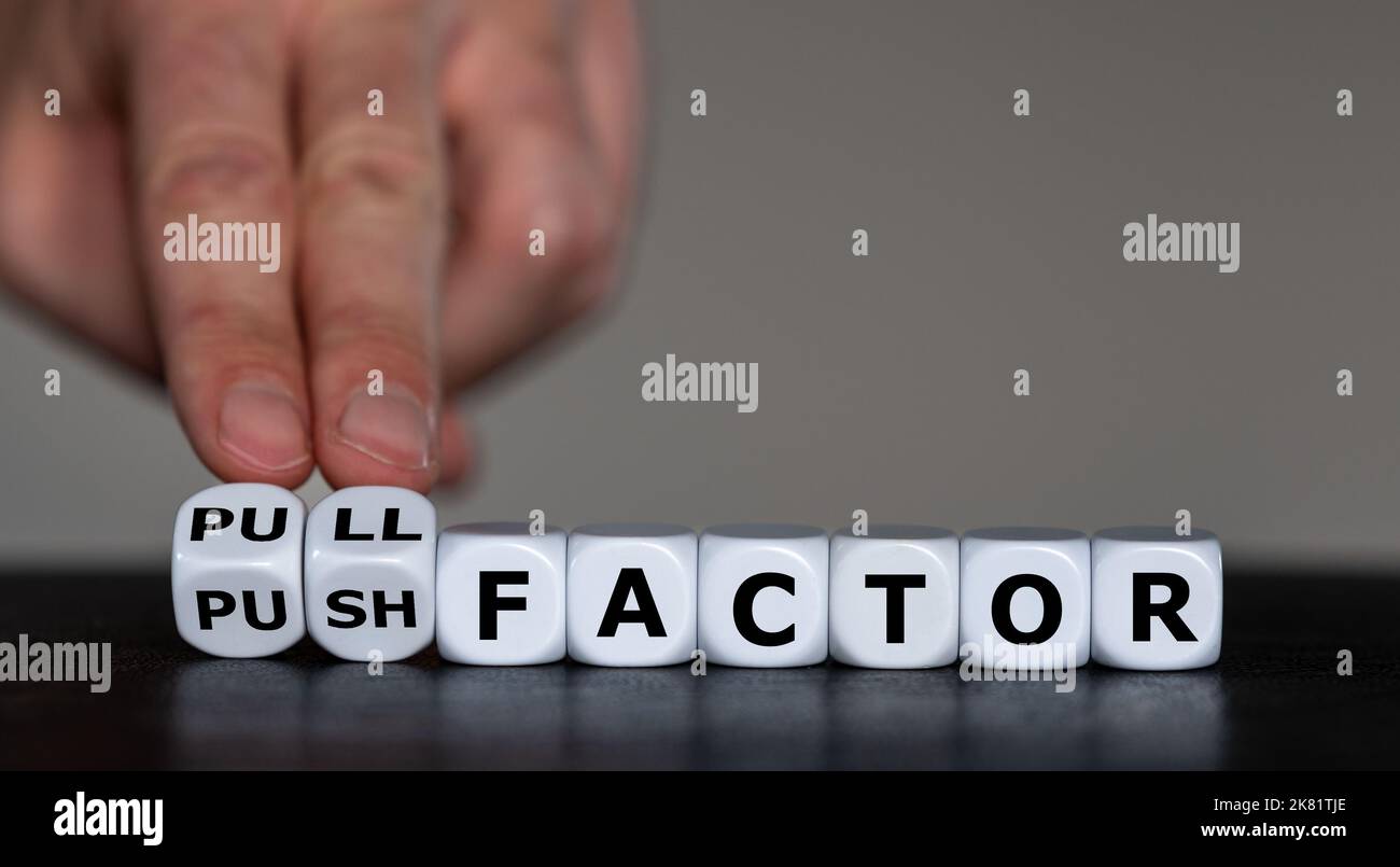 Dice form the expression 'pull factor' and 'push factor'. Symbol for reasons of migration. Stock Photo