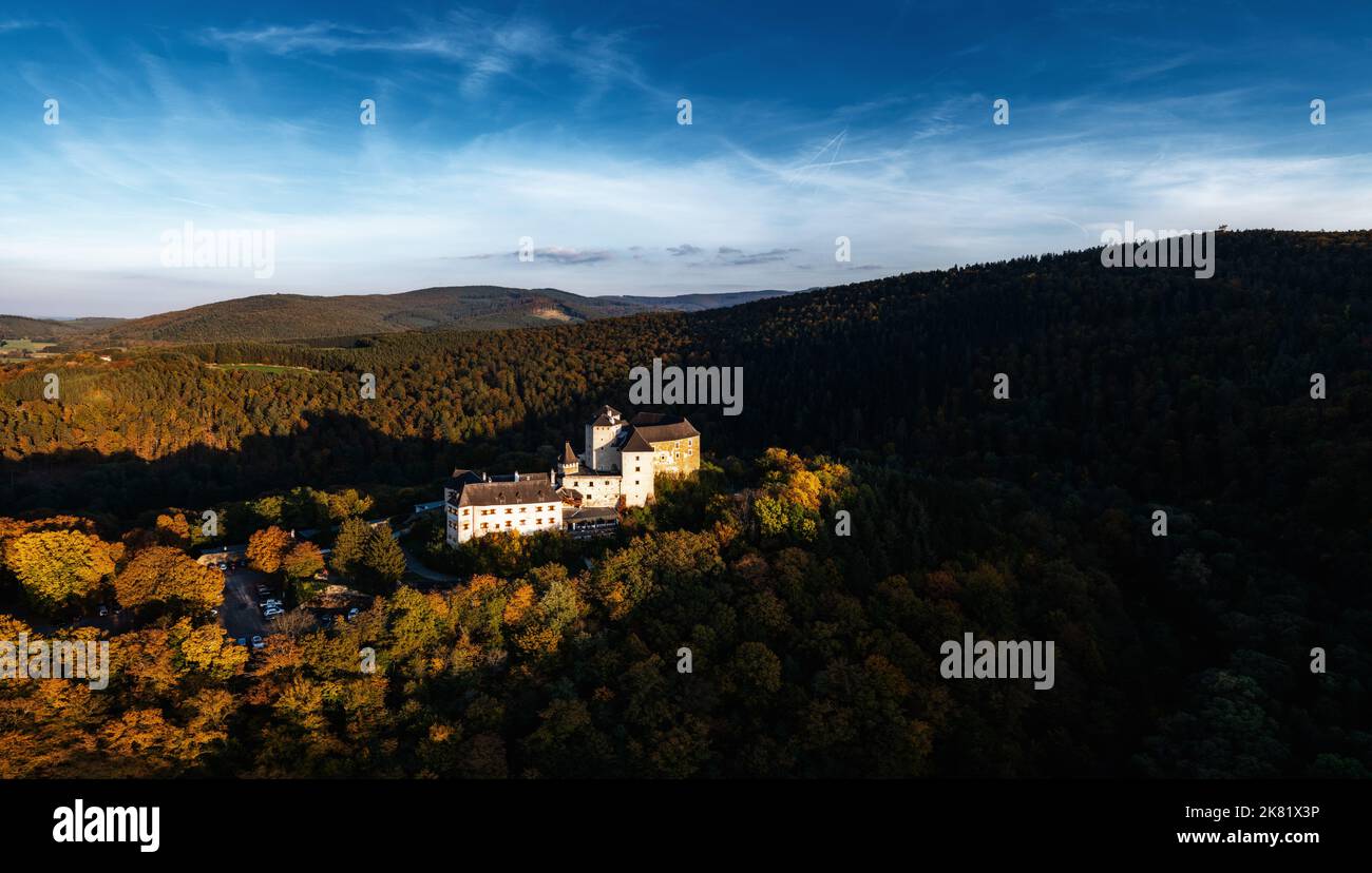 Lockenhaus, Austria - 7 October, 2022: panorama of Lockenhaus Castle surrounded by autumn forest in warm evening light Stock Photo