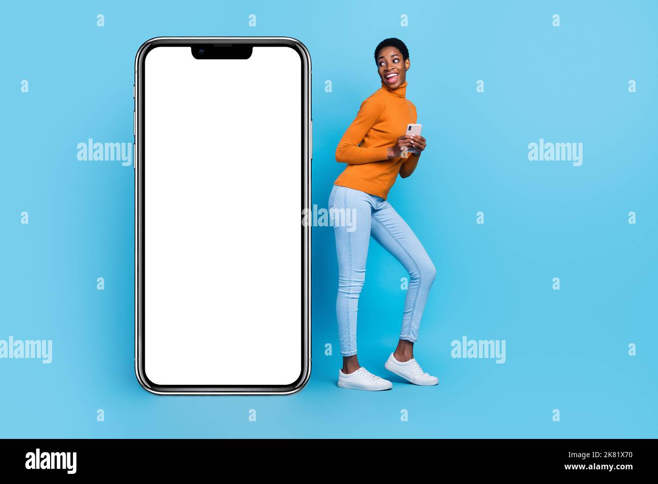 Full body photo of cheerful trans identity bi woman use smartphone see empty copy blank space isolated on blue color background Stock Photo