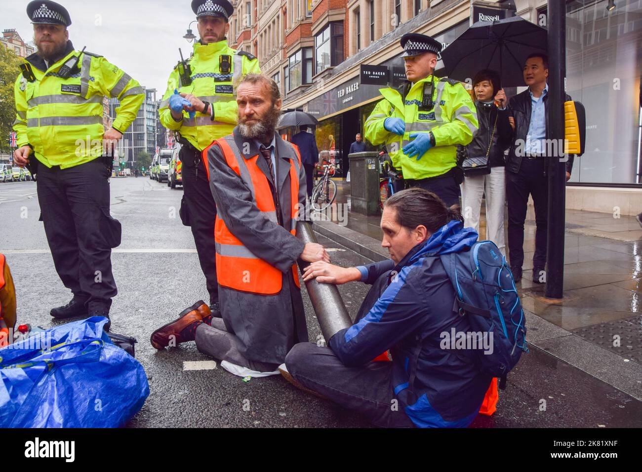 London, UK. 20th October 2022. Protesters with their arms attached to a