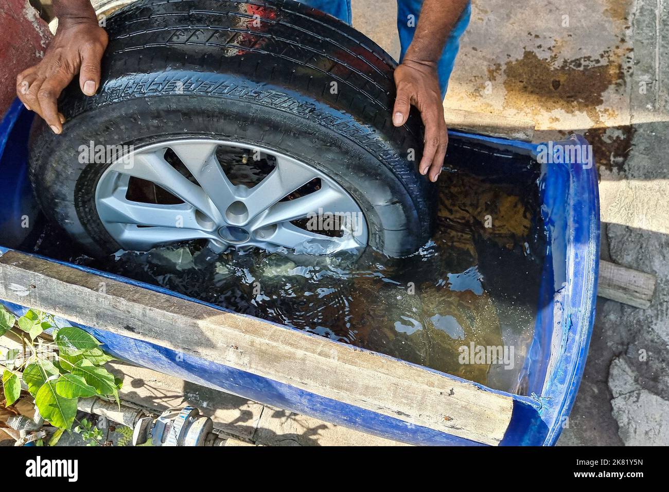 Worker submerge tyre into water container for bubble to check point of