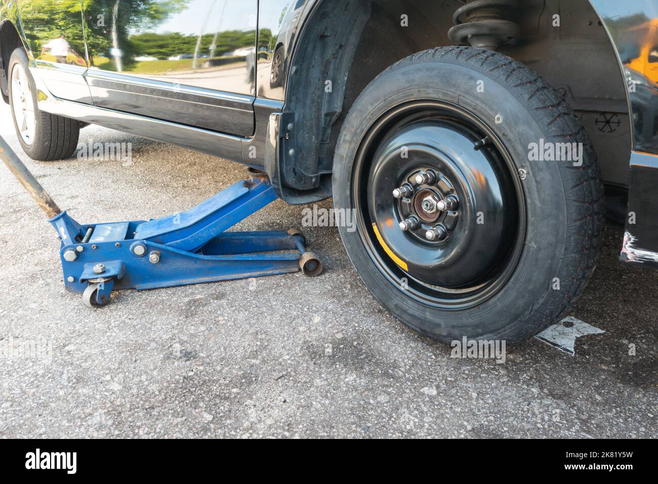 Hydraulic car jack lift car to replace punctured tyre with temporary