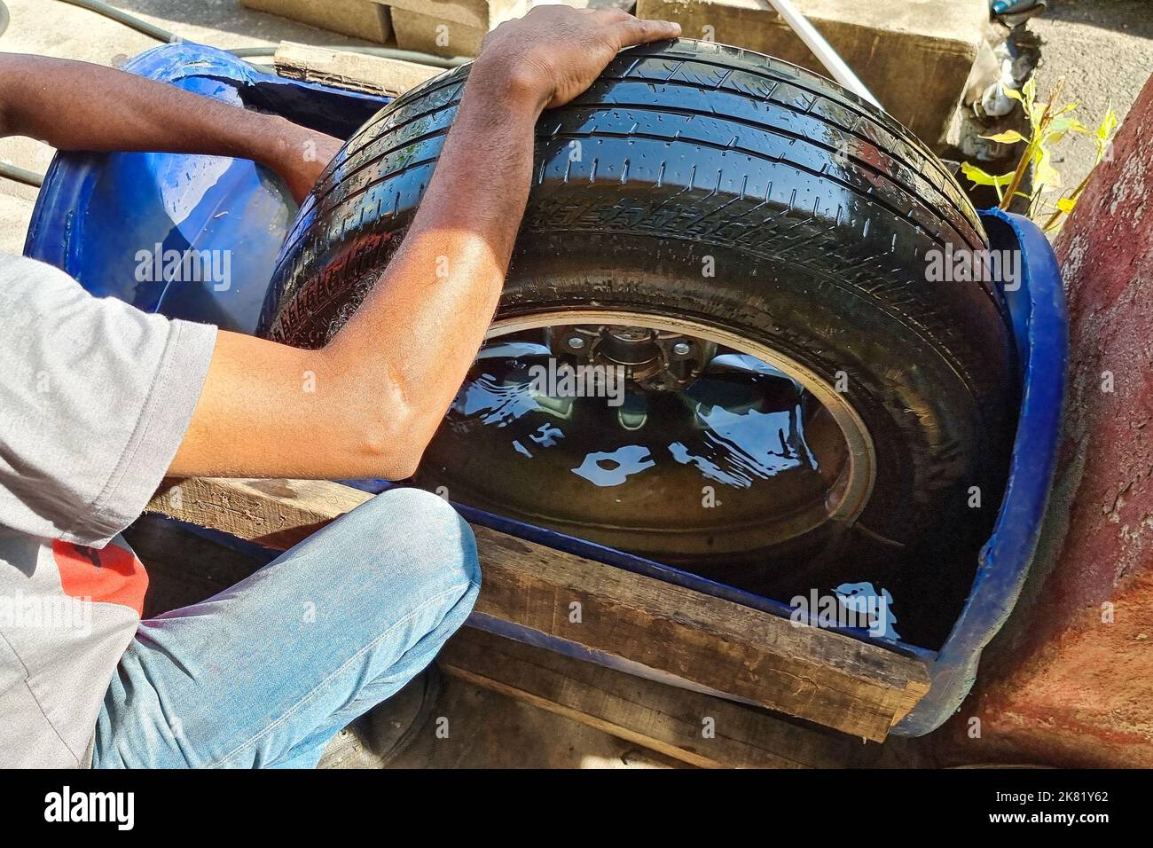 Worker submerge tyre into water container for bubble to check point of