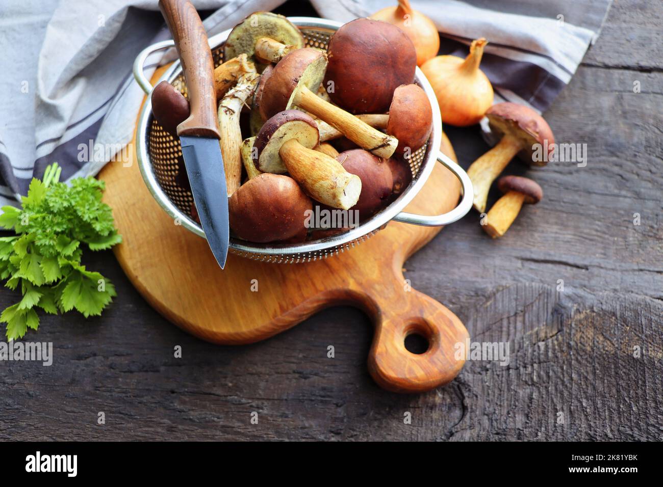 Forest boletus mushrooms on rustic wooden background and a wooden cutting board Stock Photo