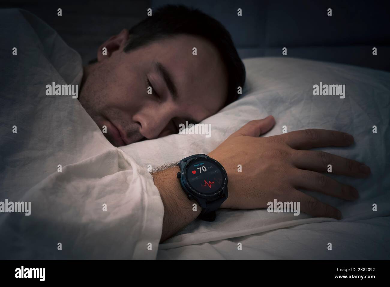 Fitness Activity Tracker With Heartbeat Rate On Man's Hand Over Bed. a