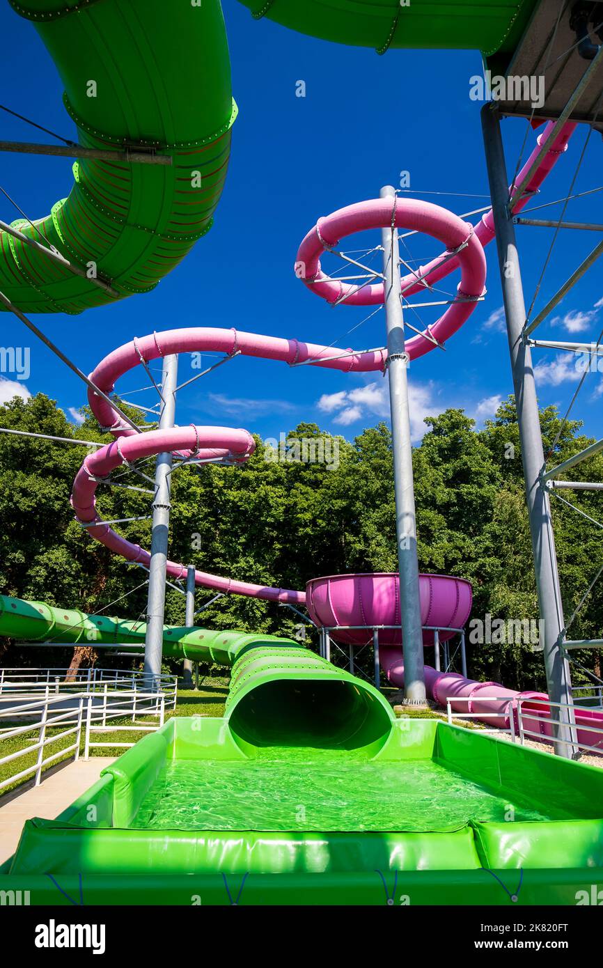 Yellow and green water slide in aquapark Stock Photo - Alamy