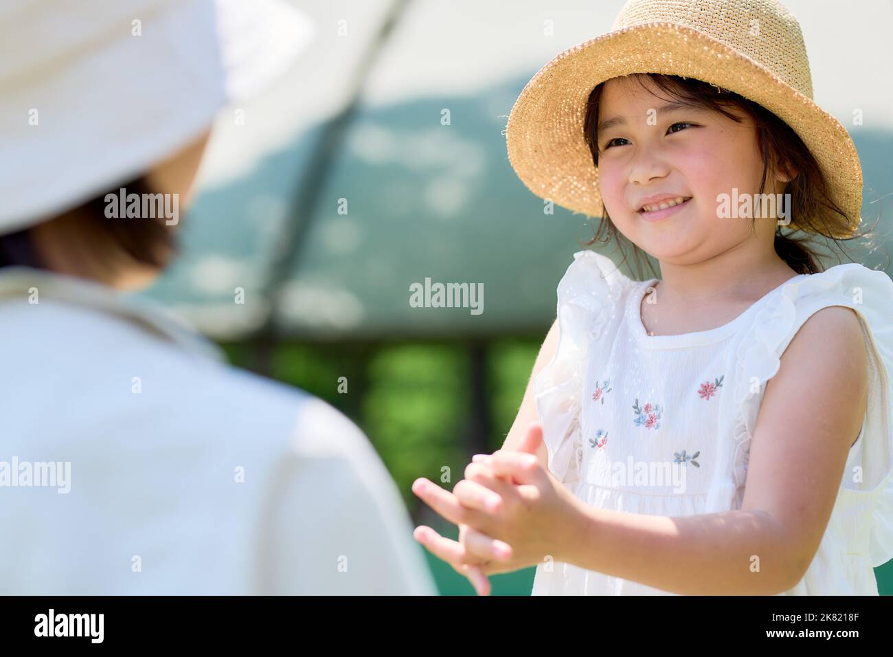 Japanese kid using hand sanitizer at a city park Stock Photo