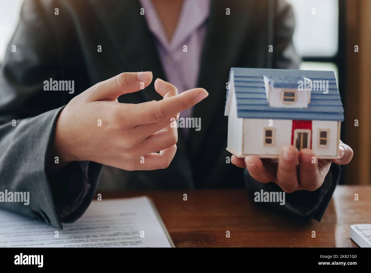 The real estate agent is showing the house model to the customer Stock ...