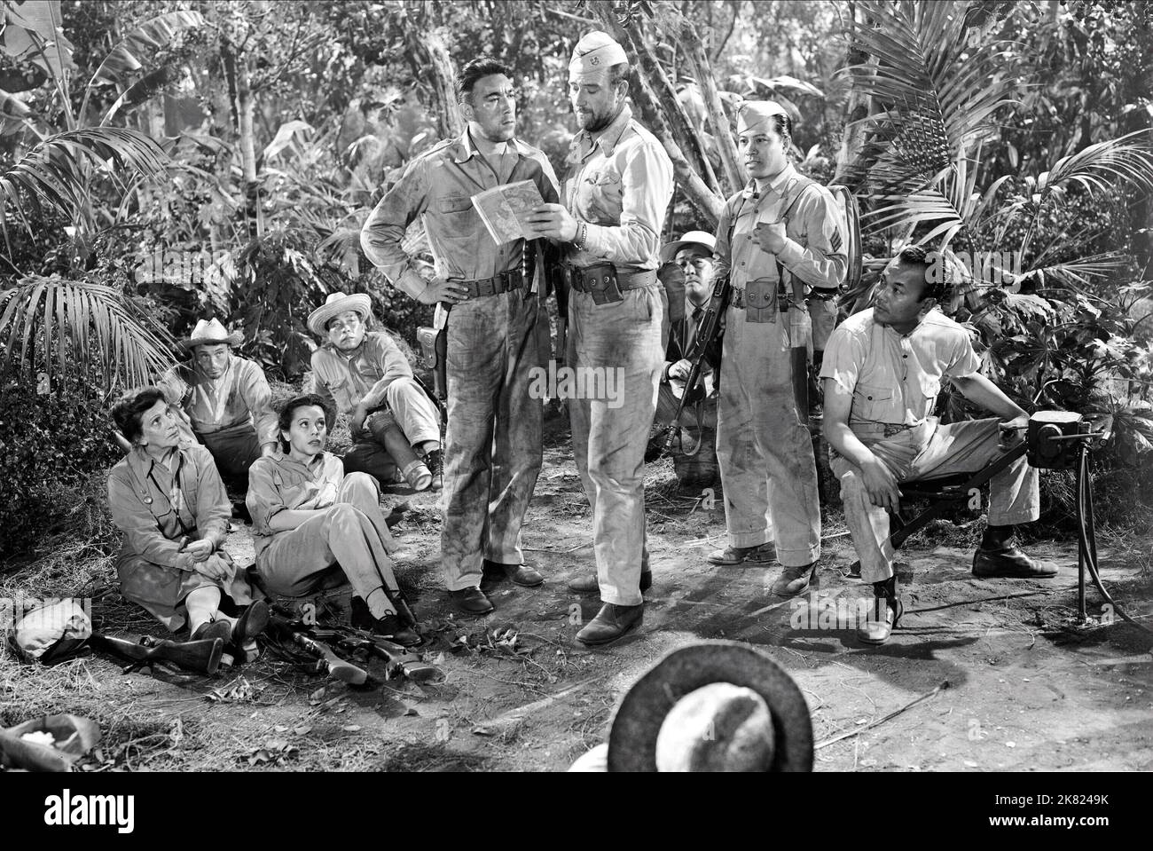 Beulah Bondi, Fely Franquelli, Anthony Quinn & John Wayne Film: Back To Bataan (USA 1945) Characters: Bertha Barnes, Dolici Dalgado, Capt. Andres Bonifacio, Col. Joseph Madden  Director: Edward Dmytryk 31 May 1945   **WARNING** This Photograph is for editorial use only and is the copyright of RKO PICTURES and/or the Photographer assigned by the Film or Production Company and can only be reproduced by publications in conjunction with the promotion of the above Film. A Mandatory Credit To RKO PICTURES is required. The Photographer should also be credited when known. No commercial use can be gran Stock Photo