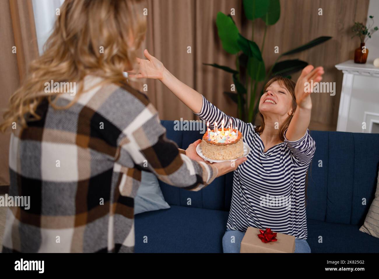 Woman gives her daughter a birthday cake. Thank you mom for the
