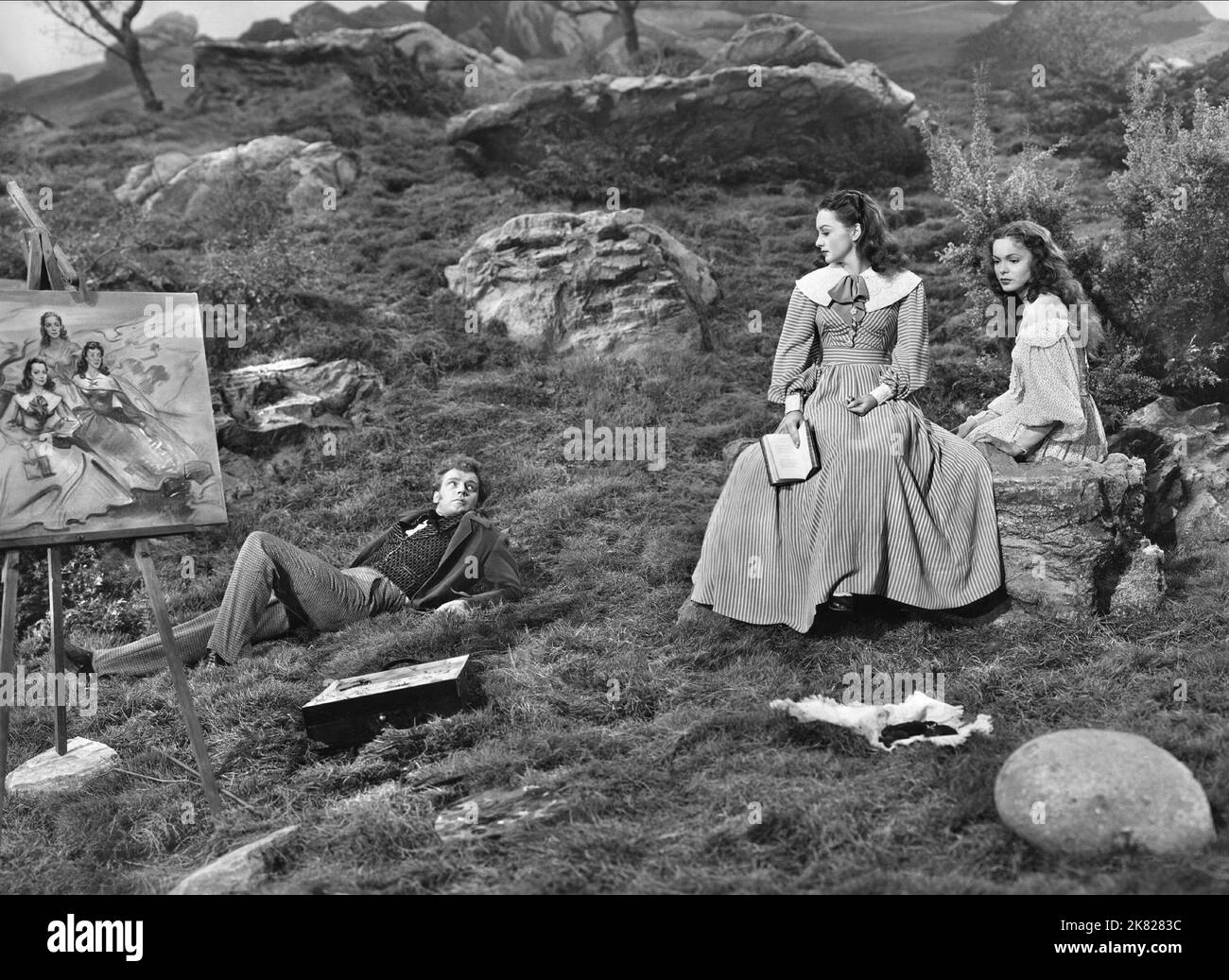 Arthur Kennedy, Olivia De Havilland & Nancy Coleman Film: Devotion (USA 1946) Characters: Branwell Bronte, Charlotte Bronte, Anne Bronte  Director: Ccurtis Bernhardt 05 April 1946   **WARNING** This Photograph is for editorial use only and is the copyright of WARNER BROS. and/or the Photographer assigned by the Film or Production Company and can only be reproduced by publications in conjunction with the promotion of the above Film. A Mandatory Credit To WARNER BROS. is required. The Photographer should also be credited when known. No commercial use can be granted without written authority from Stock Photo