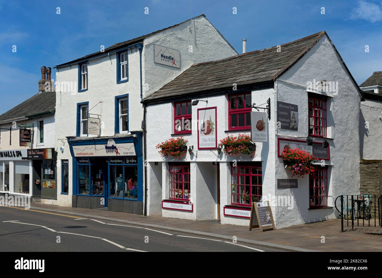 The Wild Strawberry restaurant cafe and Needle sports walking climbing shop summer Main Street Town Centre Keswick Cumbria England UK England Stock Photo