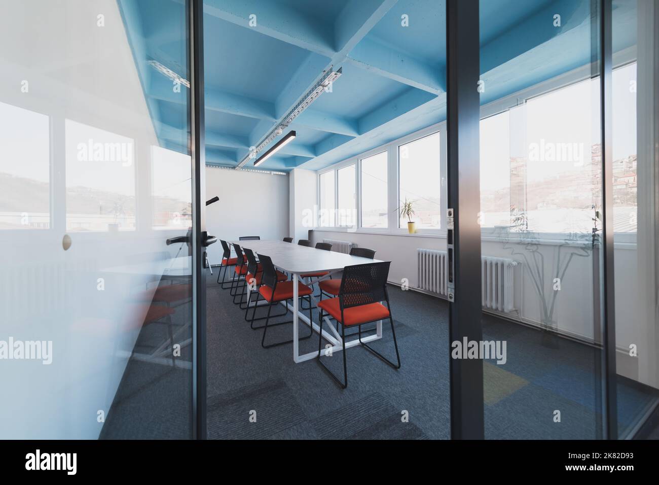 Interior of cozy light boardroom with table, modern stylish chairs and