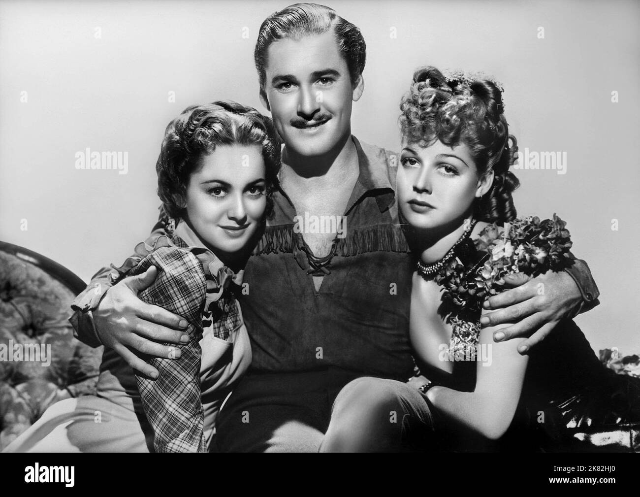 Olivia De Havilland, Errol Flynn & Ann Sheridan Film: Dodge City (USA 1939) Characters: Abbie Irving,Wade Hatton & Ruby Gilman  Director: Michael Curtiz 01 April 1939   **WARNING** This Photograph is for editorial use only and is the copyright of WARNER BROS. and/or the Photographer assigned by the Film or Production Company and can only be reproduced by publications in conjunction with the promotion of the above Film. A Mandatory Credit To WARNER BROS. is required. The Photographer should also be credited when known. No commercial use can be granted without written authority from the Film Com Stock Photo