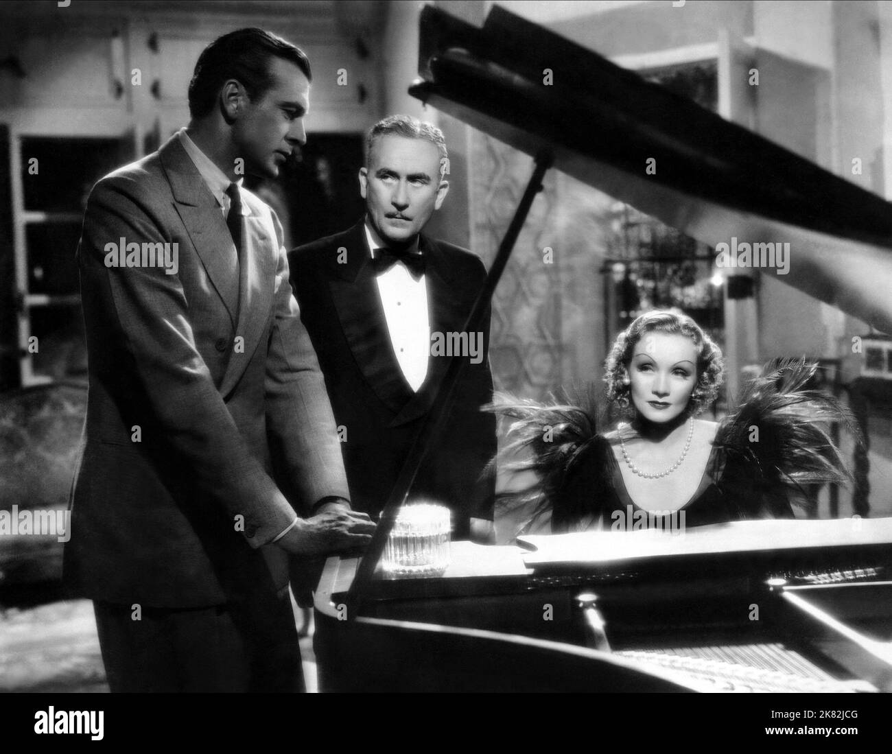 Gary Cooper, John Halliday & Marlene Dietrich Film: Desire (USA 1936) Characters: Tom Bradley, Carlos Margoli, Madeleine de Beaupre  / Titel Auch: 'Perlen Zum Glück' Director: Frank Borzage 02 April 1936   **WARNING** This Photograph is for editorial use only and is the copyright of PARAMOUNT and/or the Photographer assigned by the Film or Production Company and can only be reproduced by publications in conjunction with the promotion of the above Film. A Mandatory Credit To PARAMOUNT is required. The Photographer should also be credited when known. No commercial use can be granted without writ Stock Photo
