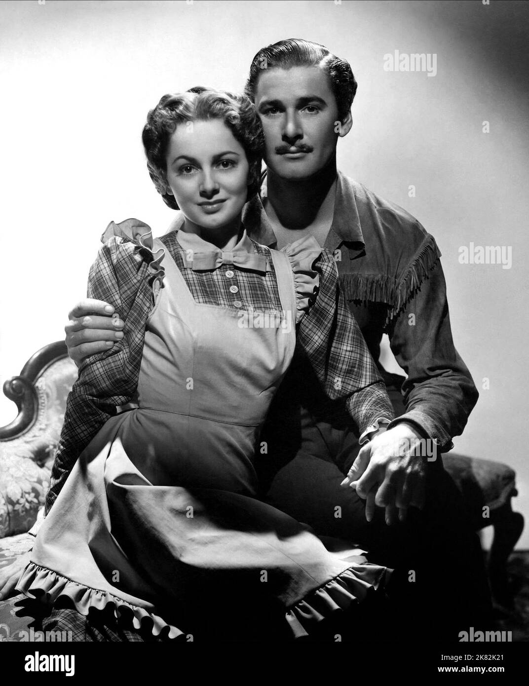 Olivia De Havilland & Errol Flynn Film: Dodge City (USA 1939) Characters: Abbie Irving, Wade Hatton  Director: Michael Curtiz 01 April 1939   **WARNING** This Photograph is for editorial use only and is the copyright of WARNER BROS. and/or the Photographer assigned by the Film or Production Company and can only be reproduced by publications in conjunction with the promotion of the above Film. A Mandatory Credit To WARNER BROS. is required. The Photographer should also be credited when known. No commercial use can be granted without written authority from the Film Company. Stock Photo