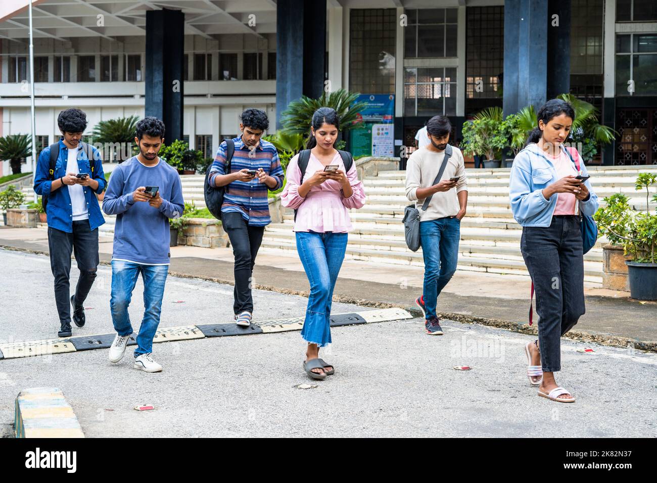 group of students busy checking result or using on mobile phone at college campus - concept of social media, smartphone addiction and technology. Stock Photo