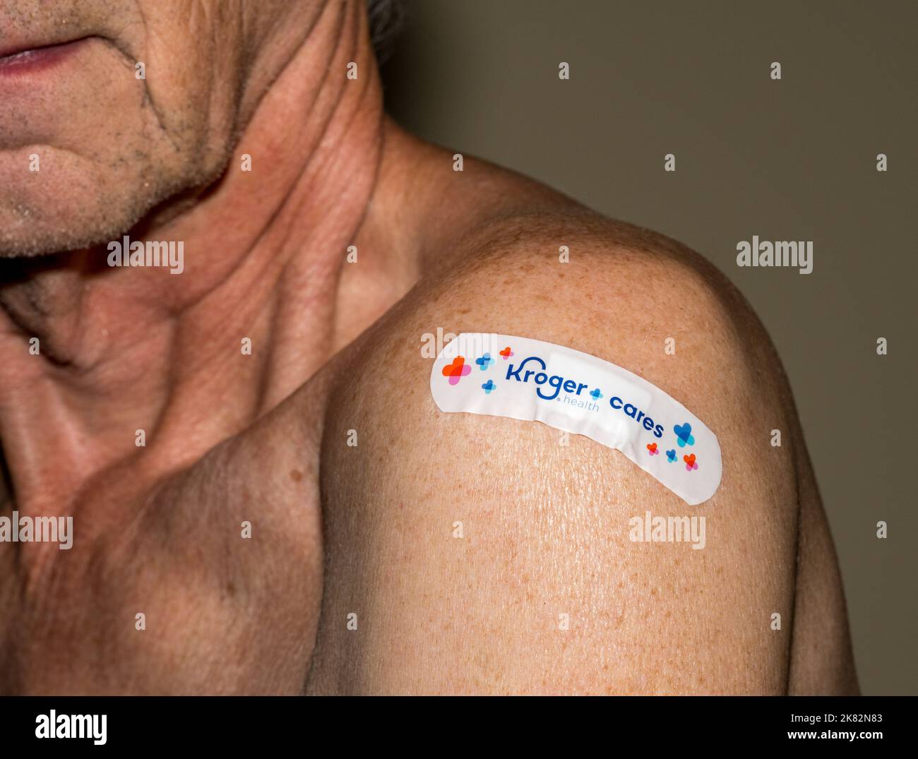Morgantown, WV - 20 October 2022: Senior man with Kroger covering over flu or covid shot in shoulder Stock Photo