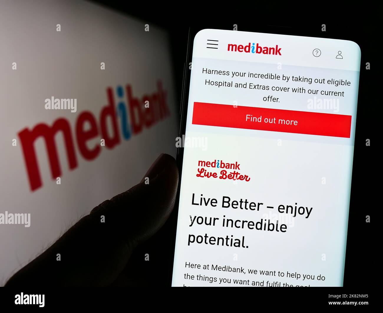 Person holding cellphone with webpage of health insurance company Medibank Private Limited on screen with logo. Focus on center of phone display. Stock Photo