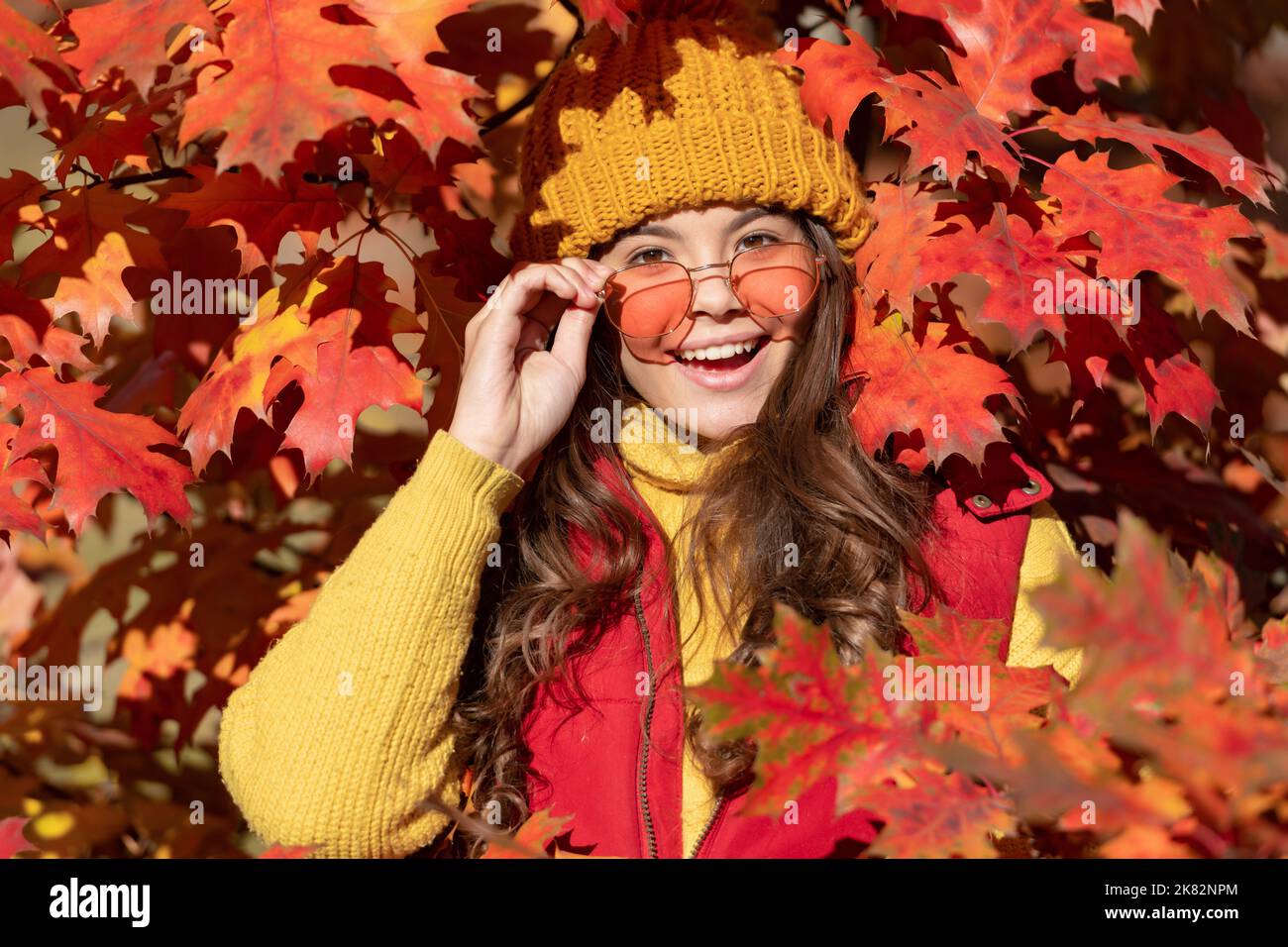 happy teen girl in sunglasses at autumn leaves on natural background ...