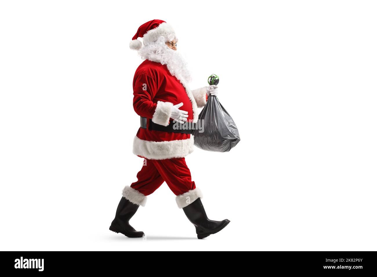 Full length profile shot of santa claus walking and carrying a plastic ...