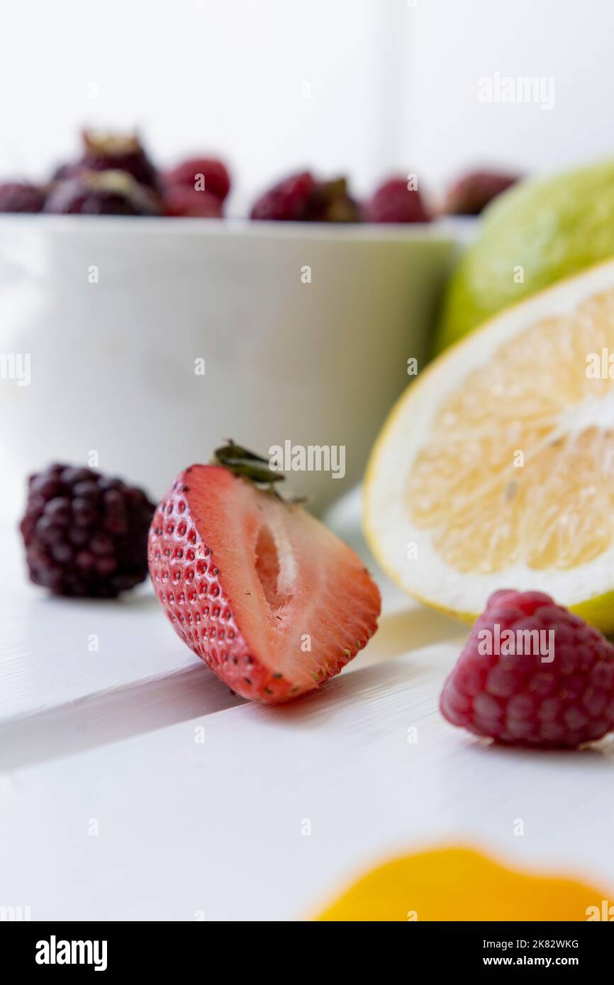 lemon, cut fruit and blackberries as wallpaper, citrus fruit with vitamin c, ingredient for healthy diet in studio, delicious and natural food Stock Photo