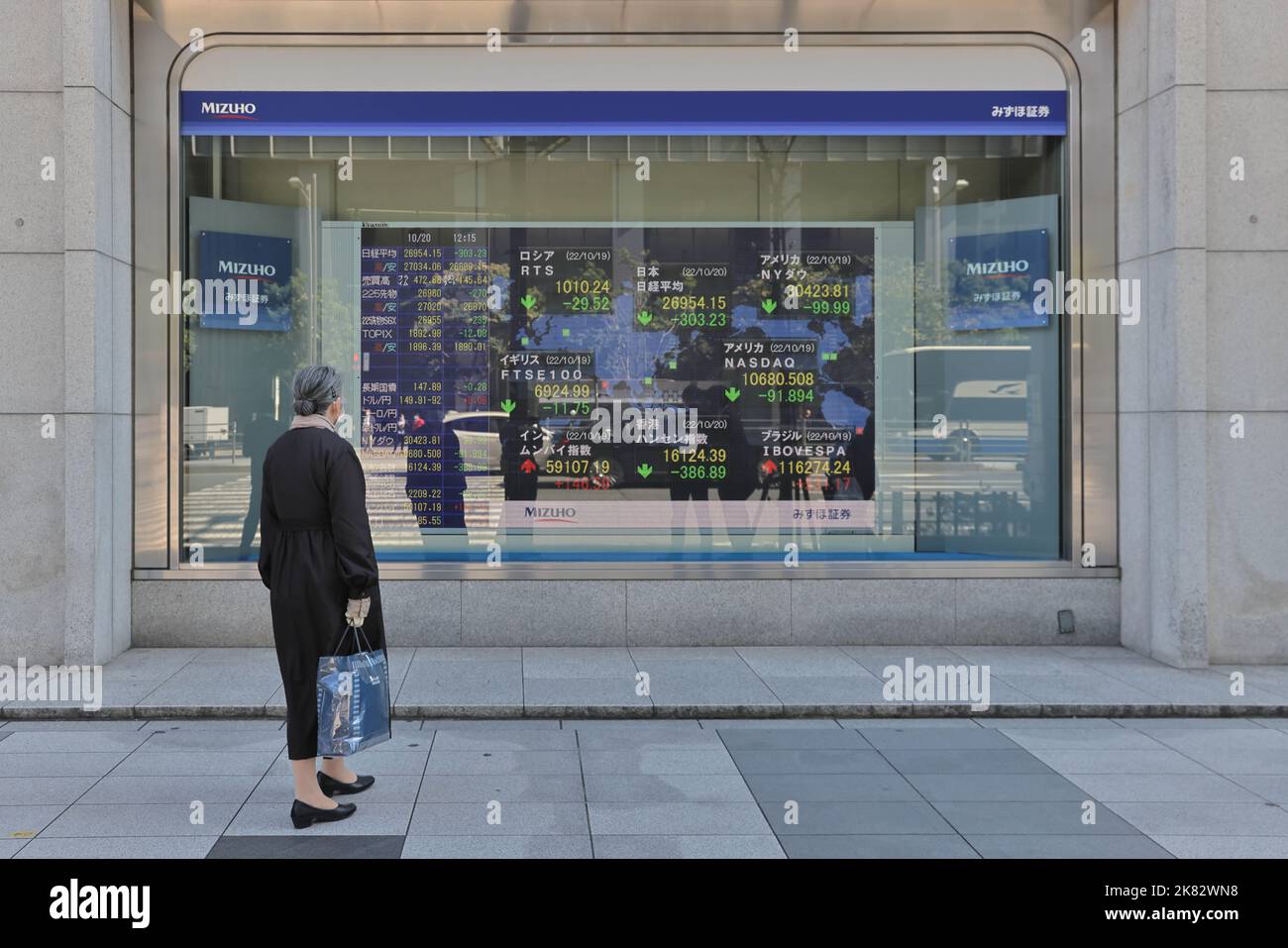 A Woman Looks At An Electronic Board Showing Economic Data In Real Time a-woman-looks-at-an-electronic-board-showing-economic-data-in-real-time