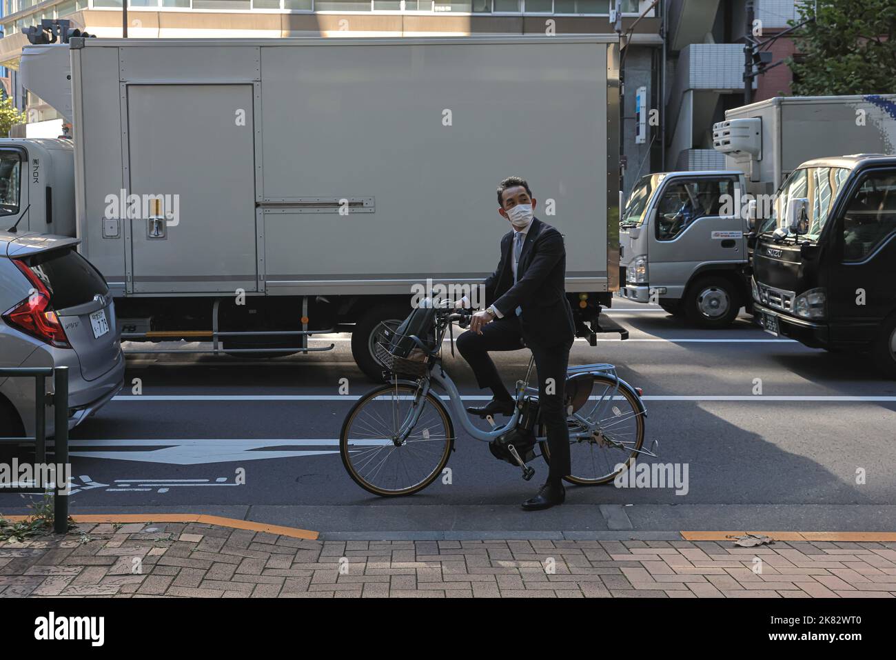 Man On A Bike Looks At An Electronic Board Which Shows Economic Data In man-on-a-bike-looks-at-an-electronic-board-which-shows-economic-data-in