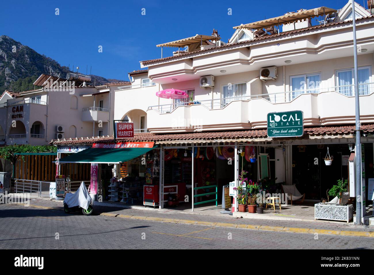 Souvenir and textile shops on picturesque street of resort village. Touristic street in Turkish town. Turunc, Turkey - September 13, 2022. Stock Photo