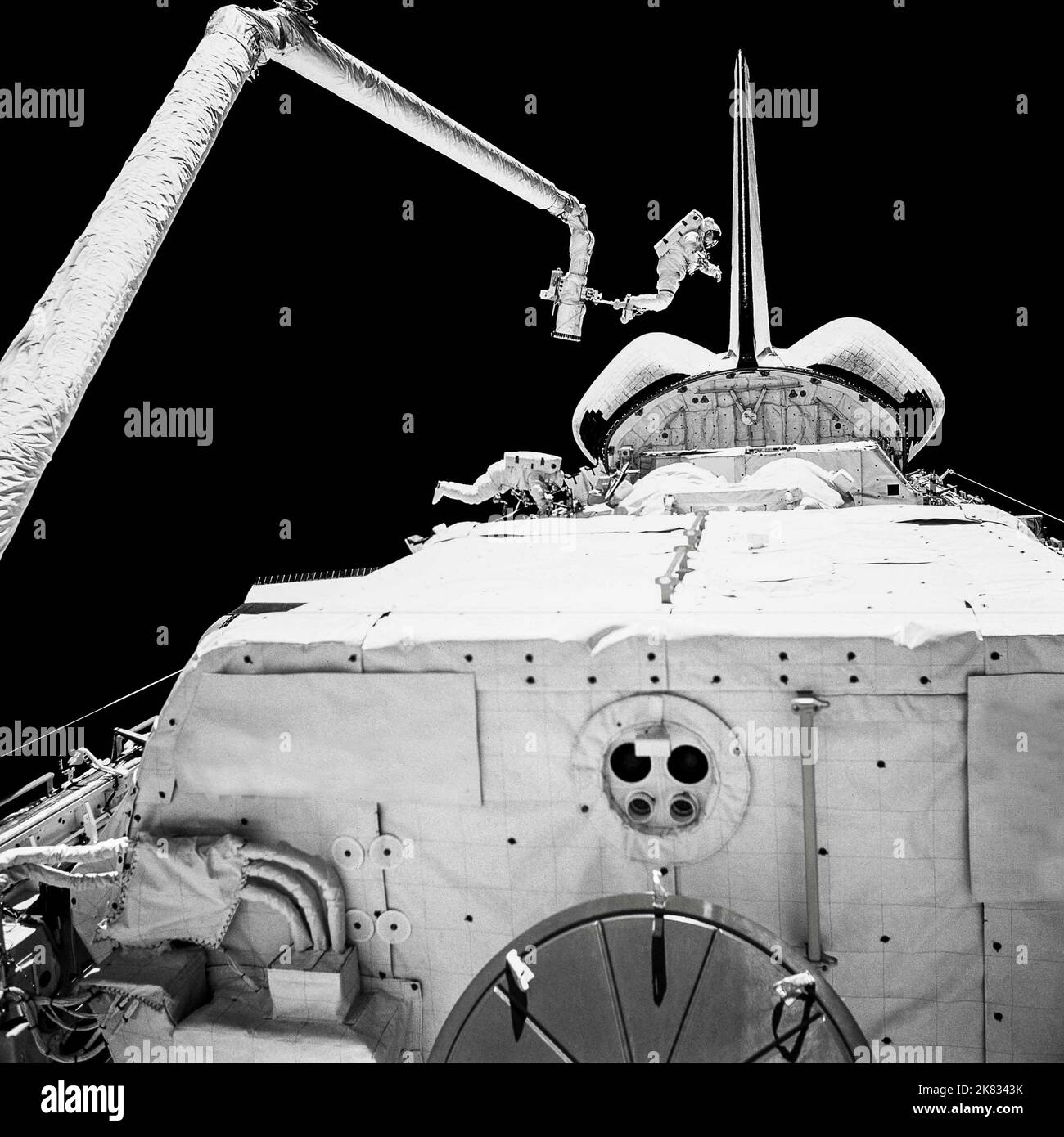 Astronauts in spacesuits work in outer space near to spaceship. Spacemans isolated on black