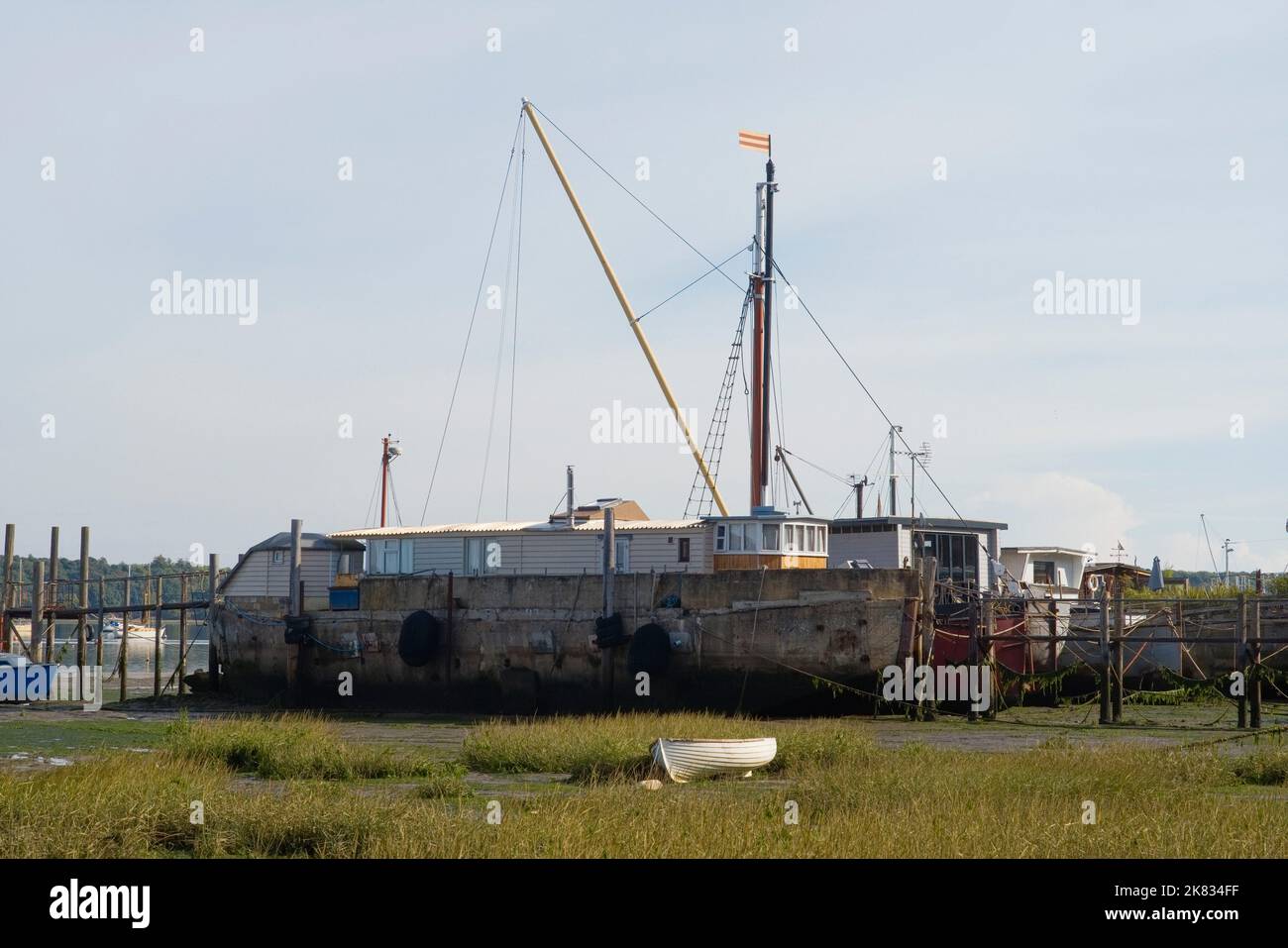 River Orwell moored houseboats at low tide with concrete barge in the foreground Stock Photo